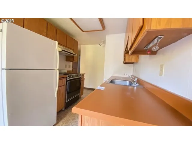 a kitchen with a refrigerator and a stove