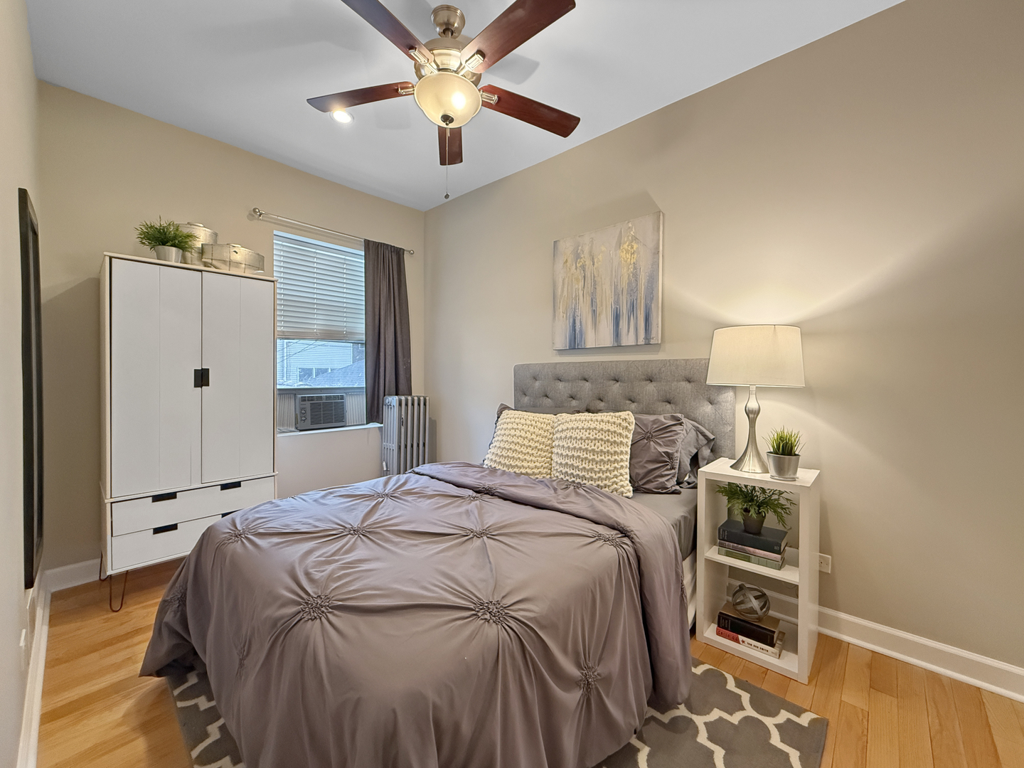 1325 West Addison Street, Unit 1A Chicago, IL 60613 - Photo 12 of 15 a bedroom with a bed and a chandelier