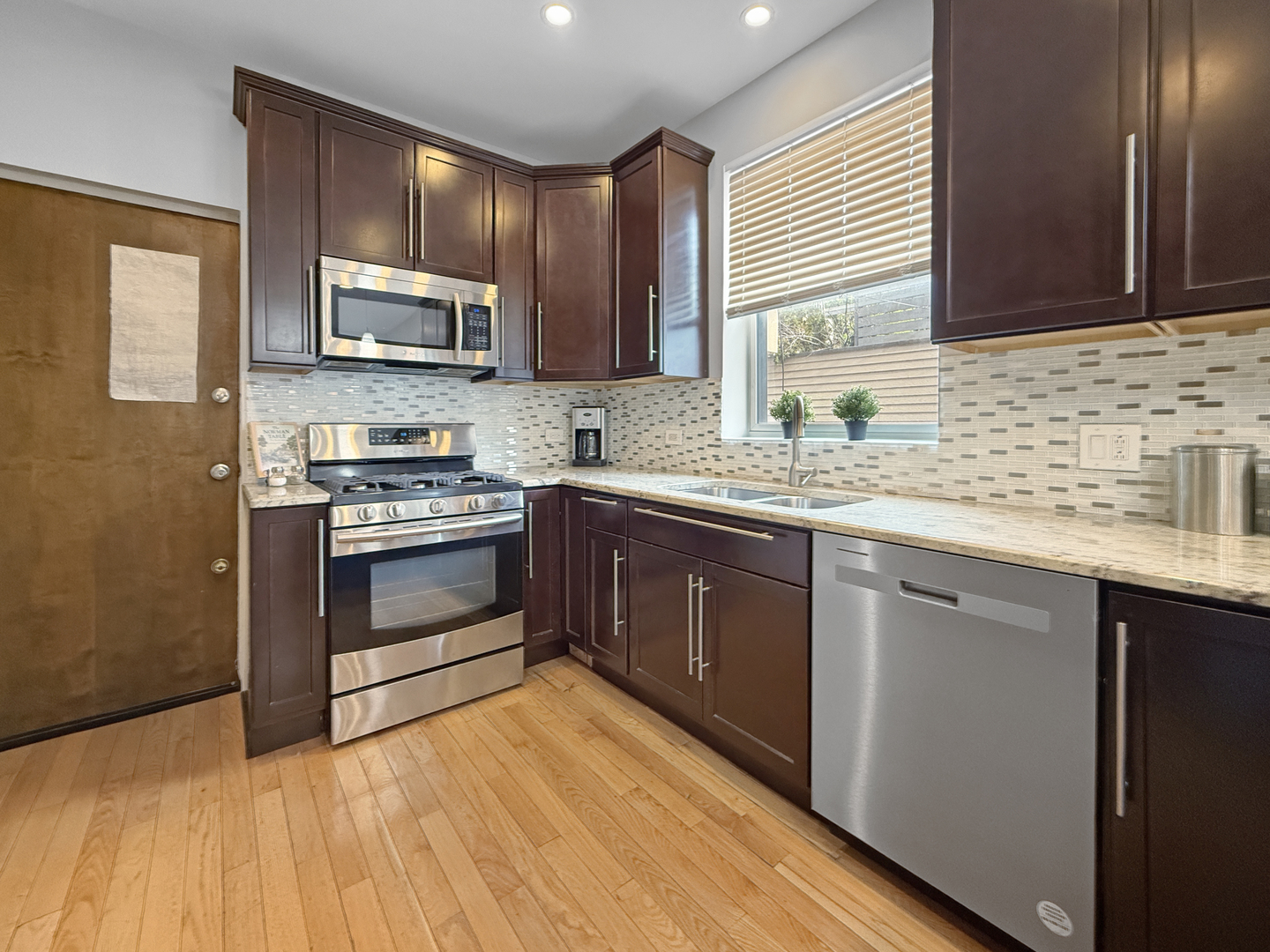 1325 West Addison Street, Unit 1A Chicago, IL 60613 - Photo 13 of 15 a kitchen with stainless steel appliances granite countertop a sink a stove a refrigerator cabinets and a window