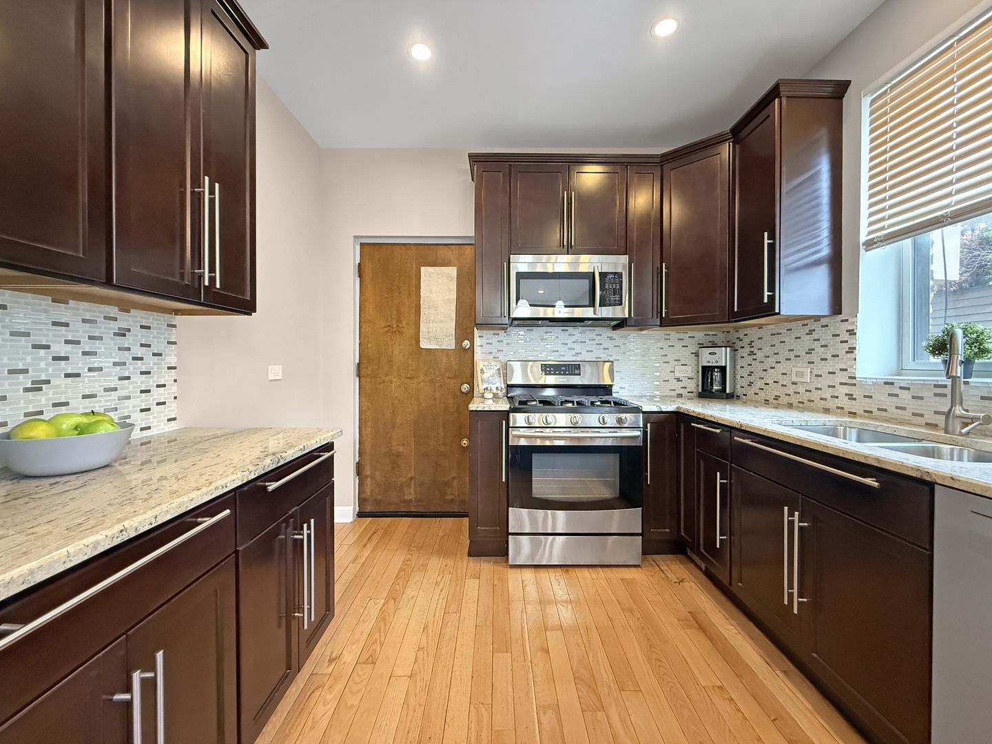 1325 West Addison Street, Unit 1A Chicago, IL 60613 - Photo 14 of 15 a kitchen with stainless steel appliances granite countertop a sink stove and refrigerator