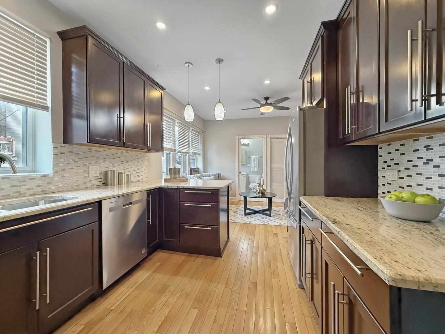1325 West Addison Street, Unit 1A Chicago, IL 60613 - Photo 5 of 15 a kitchen with kitchen island granite countertop wooden cabinets a sink and stainless steel appliances