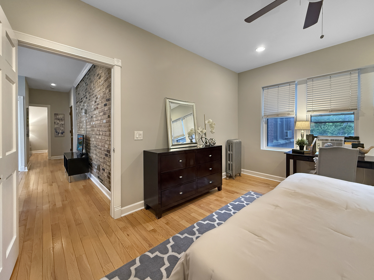 1325 West Addison Street, Unit 1A Chicago, IL 60613 - Photo 10 of 15 a large bedroom with a bed and wooden floor