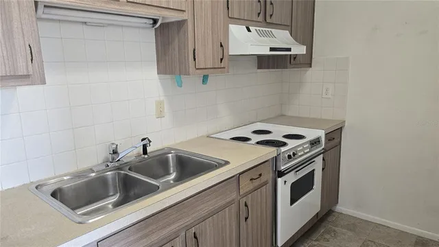 a kitchen with sink a stove and microwave