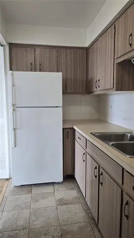 a kitchen with cabinets a refrigerator and a sink