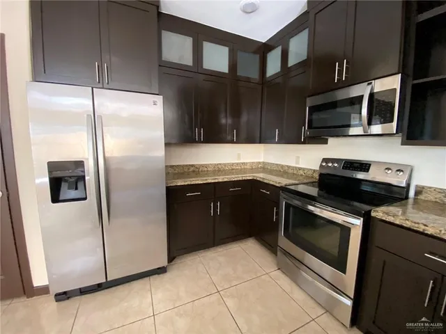 a kitchen with stainless steel appliances granite countertop a refrigerator stove and microwave