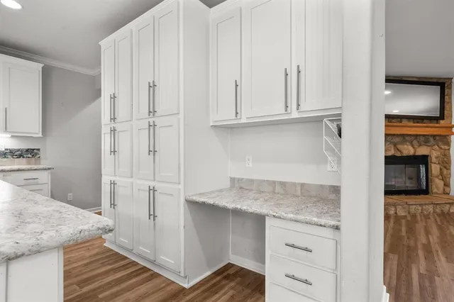 a kitchen with granite countertop white cabinets and white appliances