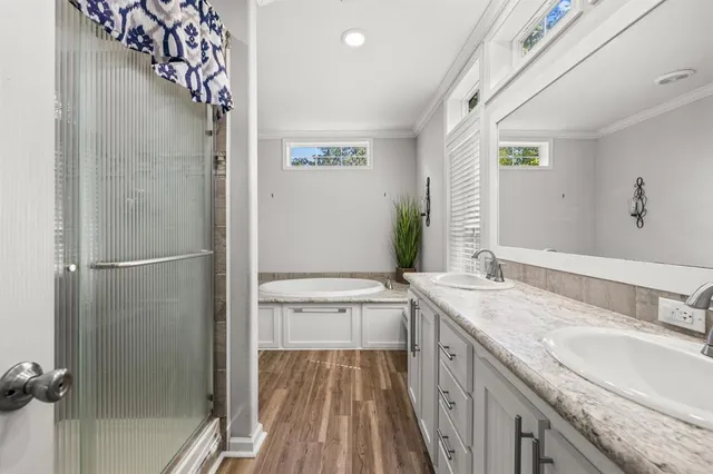 a bathroom with a granite countertop double vanity sink and mirror