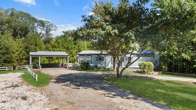 a view of a house with backyard and a tree