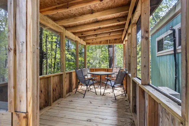 a balcony with chairs and wooden floor