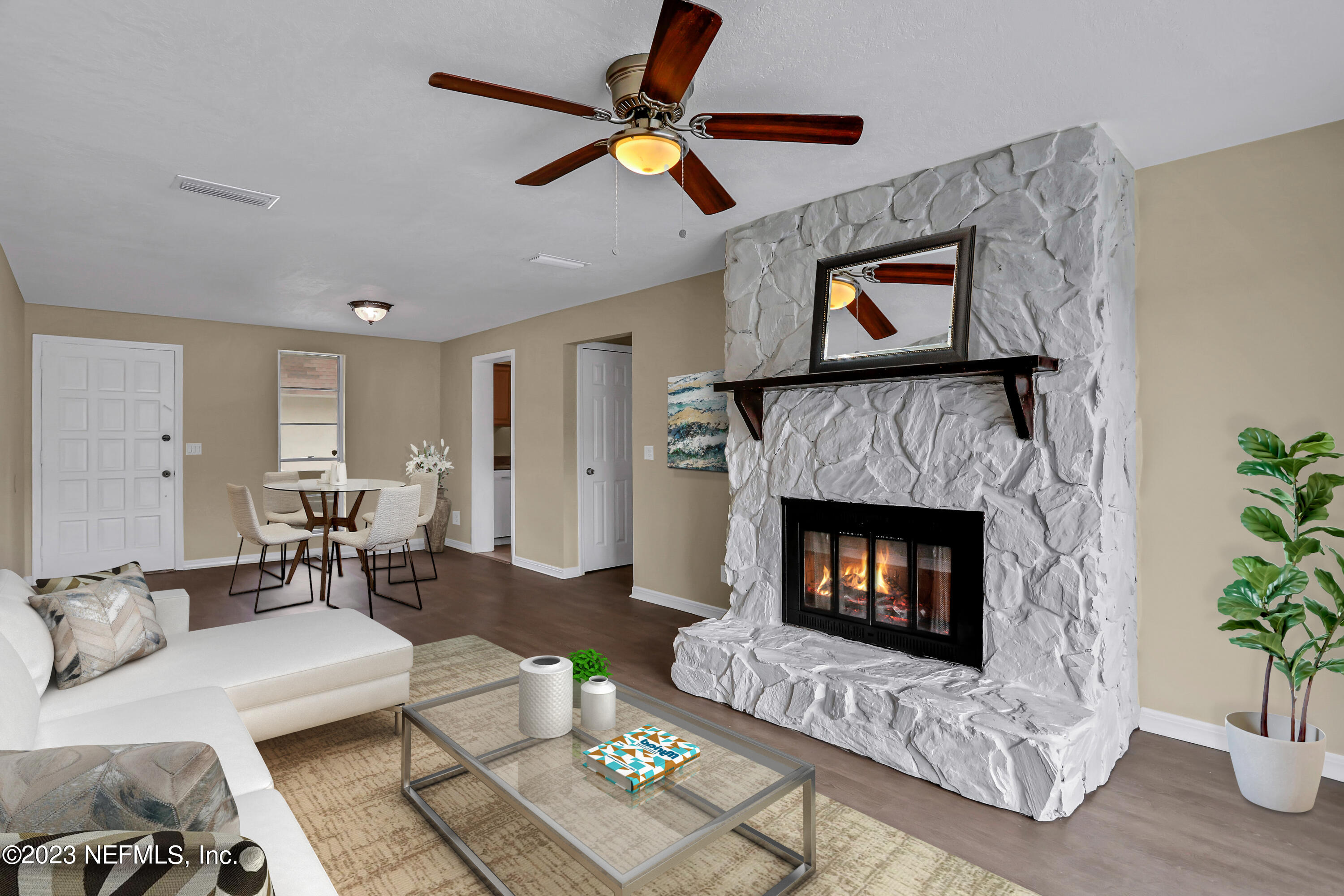 a living room with furniture a fireplace with a potted plant