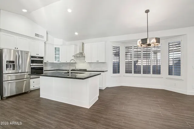 a kitchen with stainless steel appliances granite countertop a stove a sink and a refrigerator