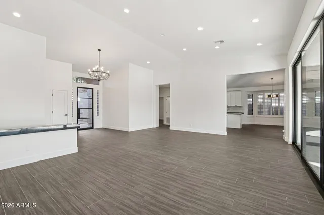 a kitchen with stainless steel appliances granite countertop a refrigerator a sink dishwasher a stove and a window with wooden floors