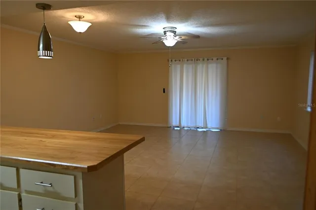 a view of a livingroom with a chandelier fan and wooden floor