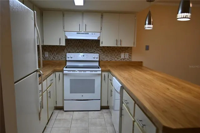 a kitchen with a stove top oven sink and cabinets