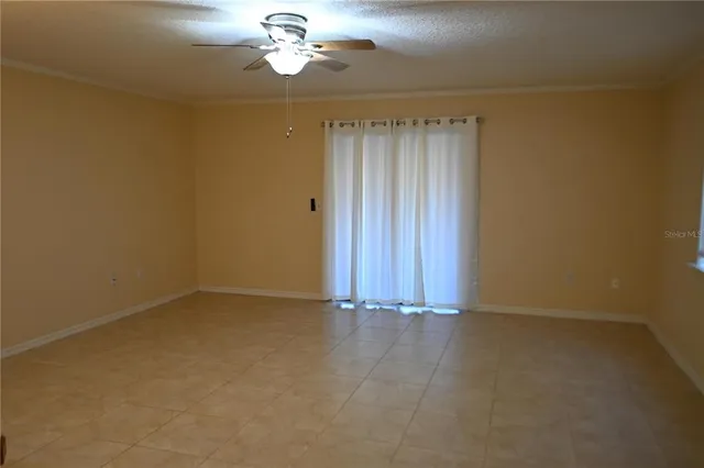 a view of an empty room with a chandelier fan