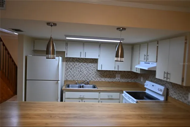 a kitchen with stainless steel appliances granite countertop a refrigerator sink and cabinets