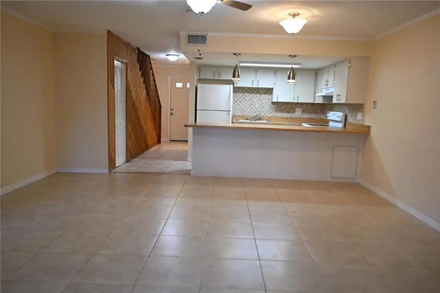 a large kitchen with granite countertop a stove a sink and a refrigerator
