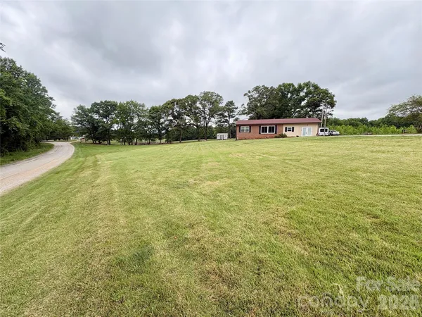 a house that has a big yard with large trees