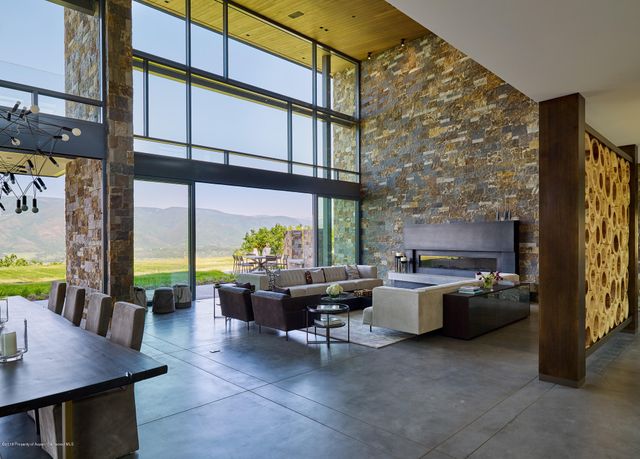 a living room with fireplace furniture and a large window
