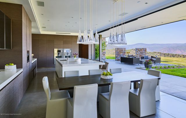 a view of a dining room with furniture a chandelier and wooden floor