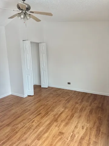 a view of a hallway with wooden floor and entryway