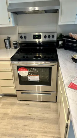 a stove top oven sitting inside of a kitchen
