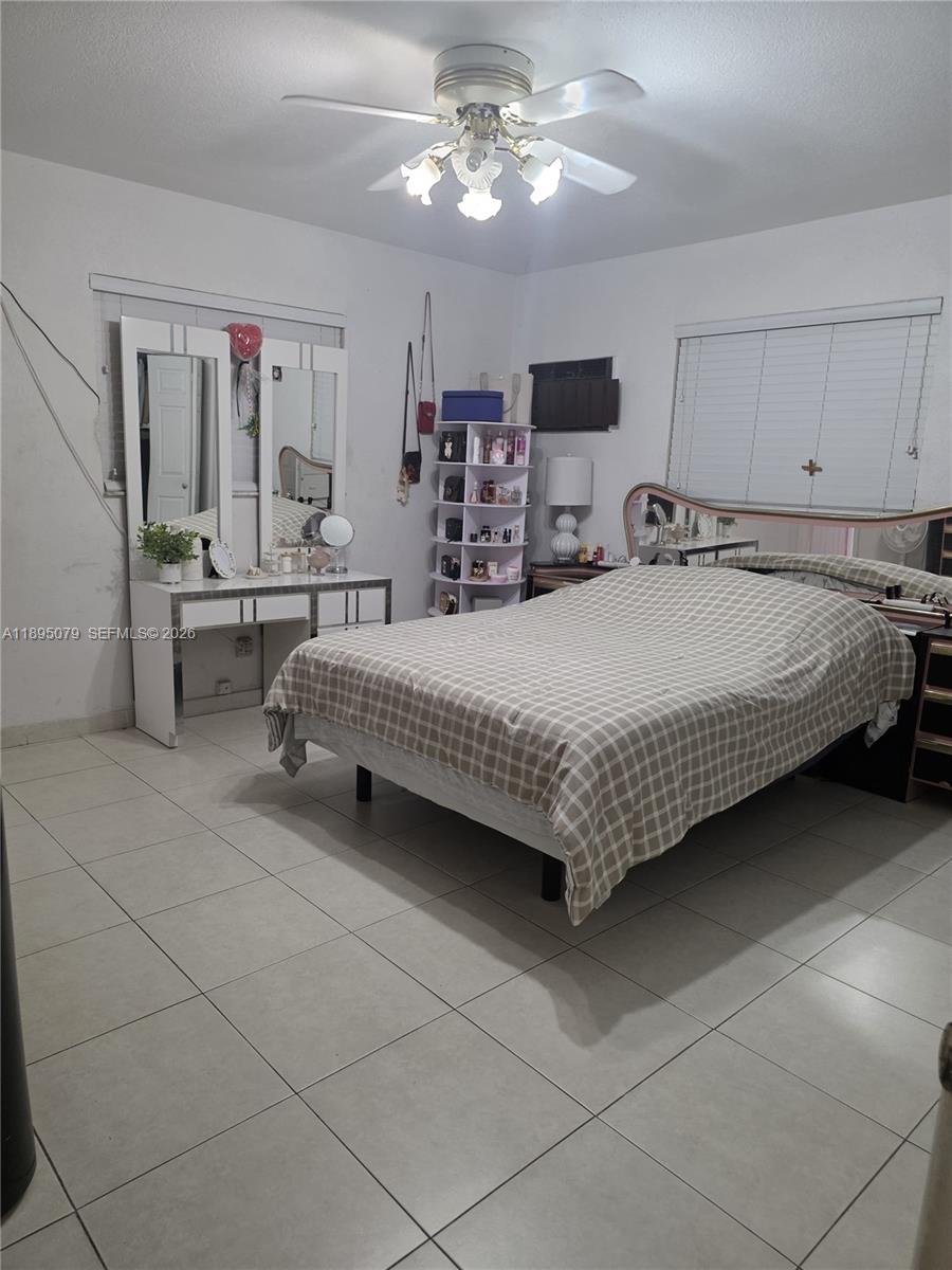 12941 Auralia Road North Miami, FL 33181 - Photo 15 of 32 a bed room with a bed mirror and a window