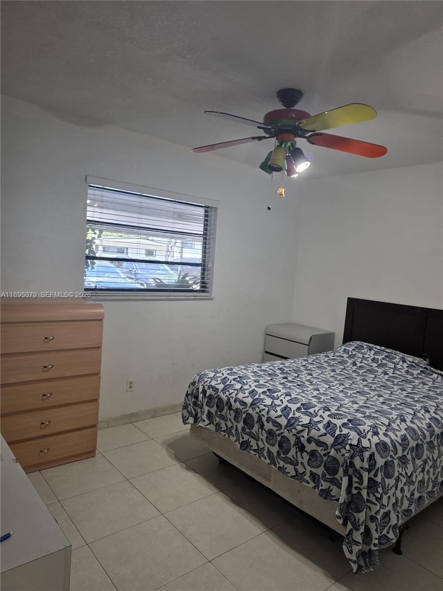12941 Auralia Road North Miami, FL 33181 - Photo 16 of 32 a bedroom with a bed and a chandelier