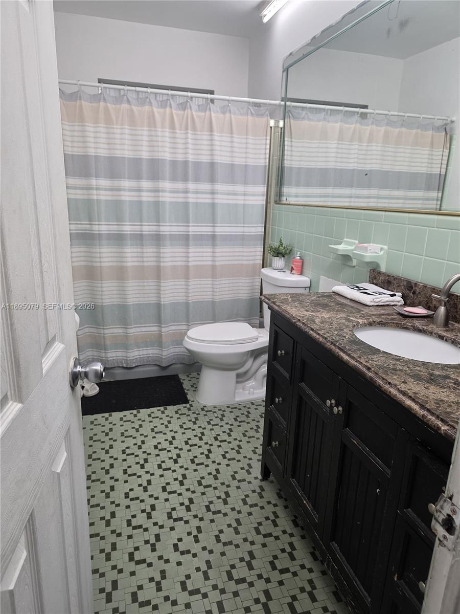 12941 Auralia Road North Miami, FL 33181 - Photo 18 of 32 a bathroom with a granite countertop sink toilet and shower