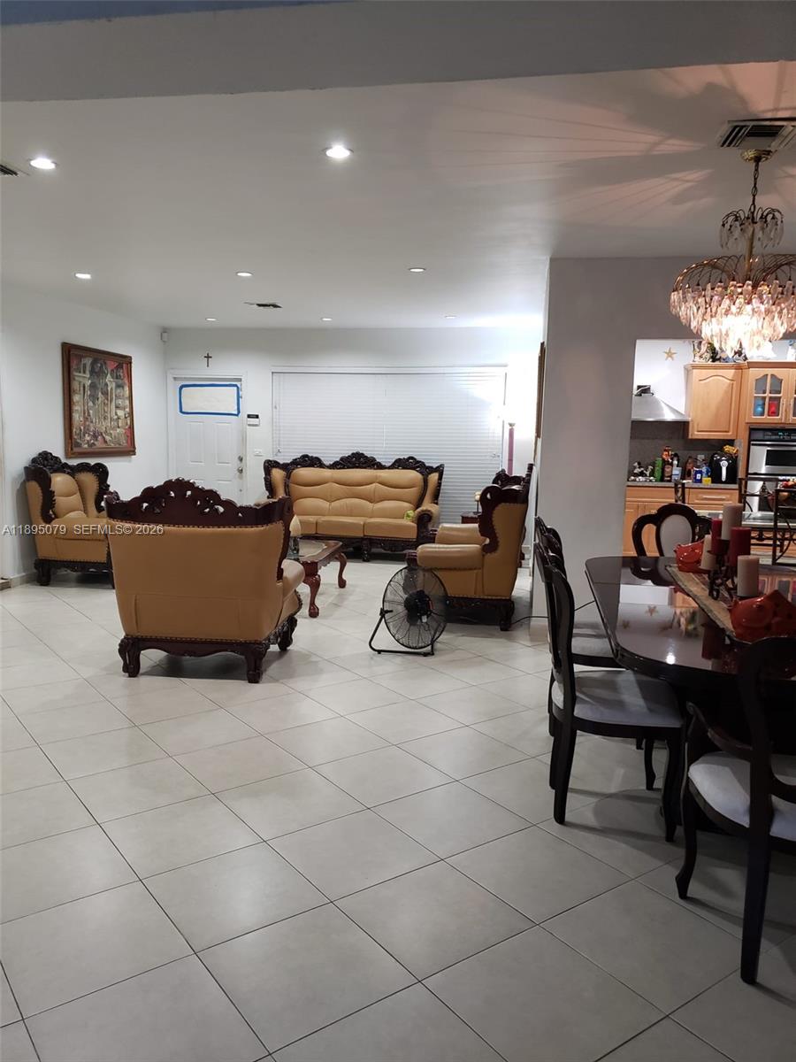 12941 Auralia Road North Miami, FL 33181 - Photo 27 of 32 a living room with furniture and a chandelier