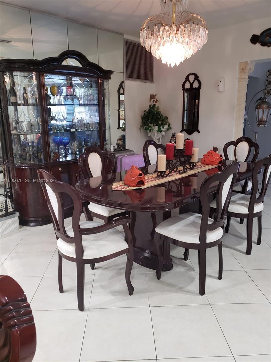 12941 Auralia Road North Miami, FL 33181 - Photo 29 of 32 a view of a dining room with furniture and chandelier