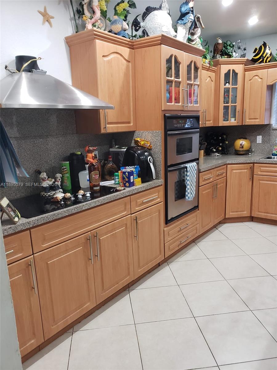 12941 Auralia Road North Miami, FL 33181 - Photo 30 of 32 a kitchen with stainless steel appliances a sink a stove and cabinets