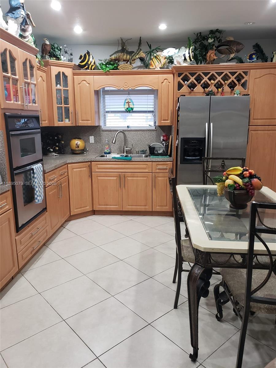 12941 Auralia Road North Miami, FL 33181 - Photo 31 of 32 a kitchen with stainless steel appliances kitchen island granite countertop a sink and cabinets
