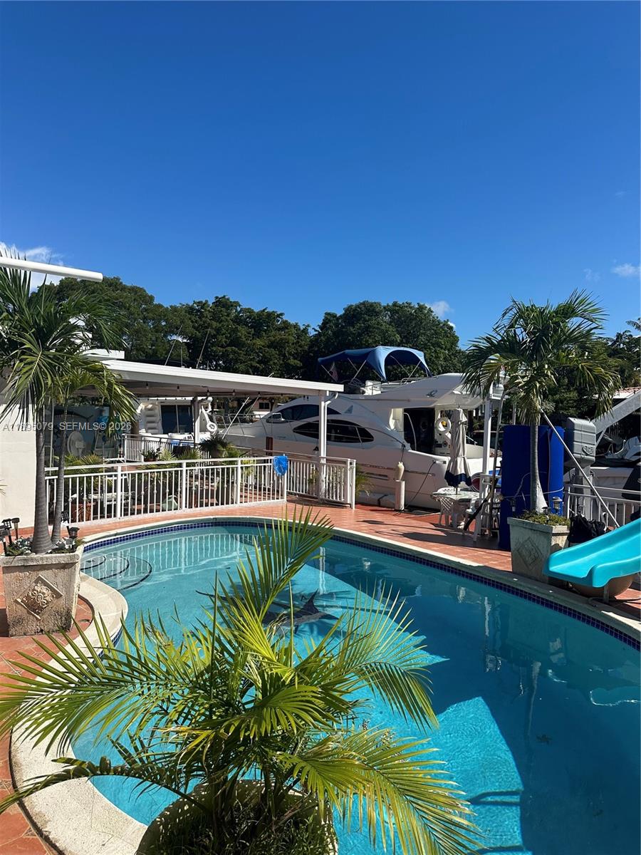 12941 Auralia Road North Miami, FL 33181 - Photo 4 of 32 a view of a swimming pool with a patio