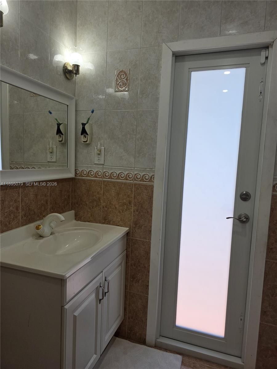 12941 Auralia Road North Miami, FL 33181 - Photo 10 of 32 a bathroom with a sink vanity and mirror
