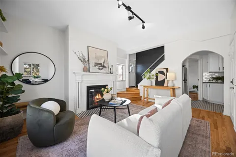 a living room with furniture a fireplace and a chandelier