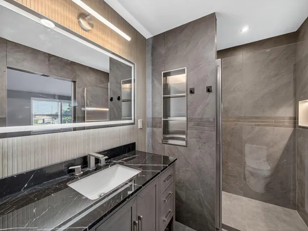 a bathroom with a granite countertop sink and a mirror