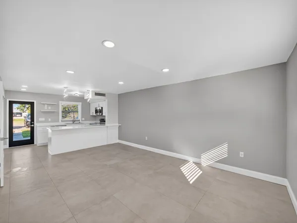 a view of an empty room with a fireplace and window