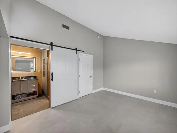 a view of an empty room with closet and a window