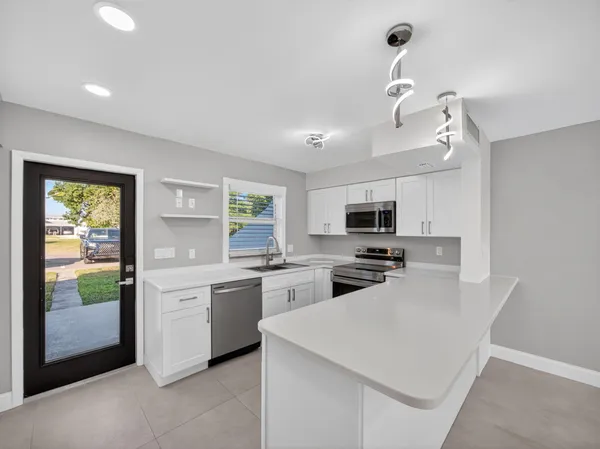 a view of a kitchen with a sink and refrigerator