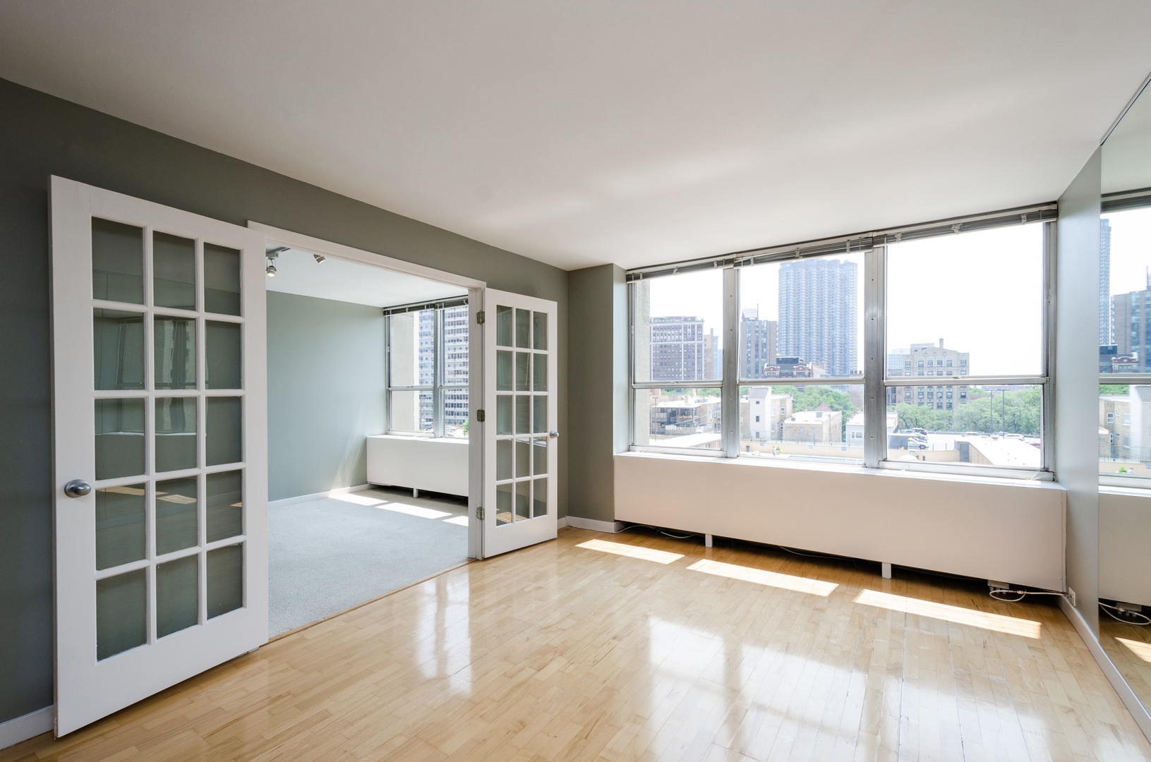 655 West Irving Park Road, Unit 407 Chicago, IL 60613 - Photo 3 of 31 a view of an empty room with a window and wooden floor