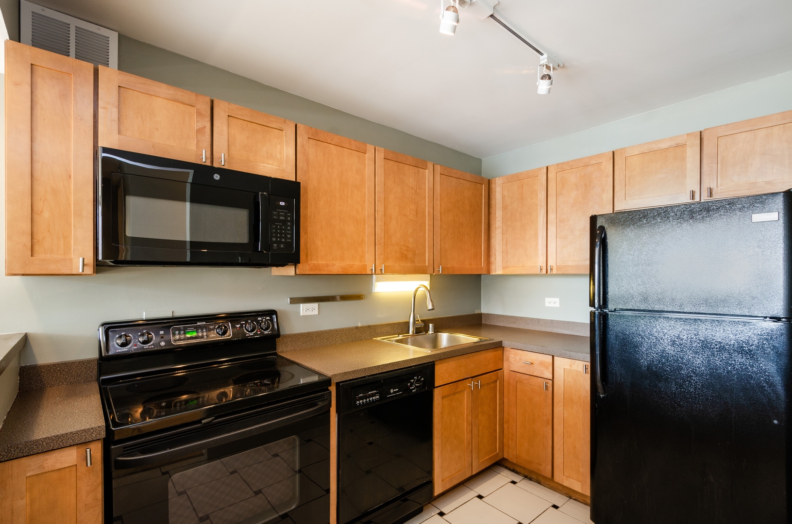 655 West Irving Park Road, Unit 407 Chicago, IL 60613 - Photo 6 of 31 a kitchen with stainless steel appliances a stove microwave and sink