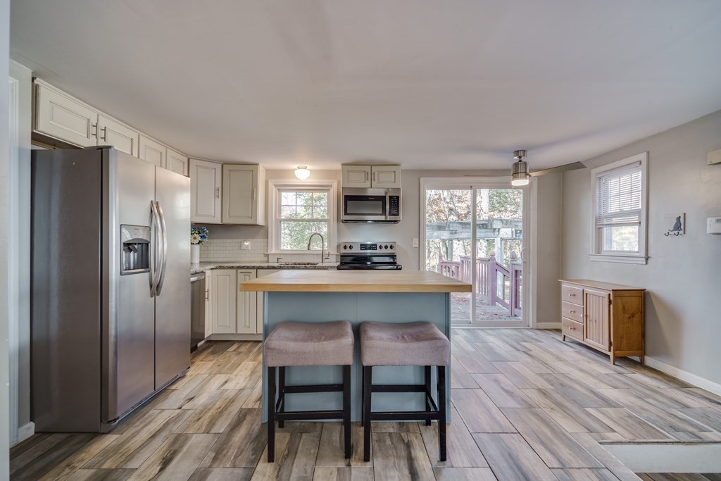 76 Wilshire Road Springfield, MA 01118 - Photo 6 of 34 a kitchen with a table chairs refrigerator and cabinets