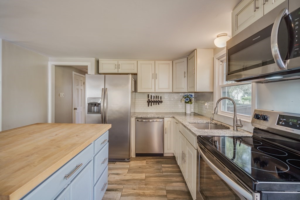 76 Wilshire Road Springfield, MA 01118 - Photo 8 of 34 a kitchen with stainless steel appliances granite countertop a sink a stove a refrigerator and cabinets
