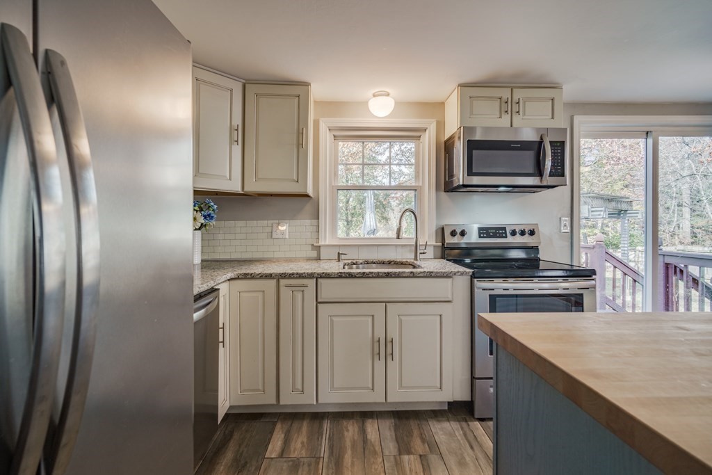 76 Wilshire Road Springfield, MA 01118 - Photo 9 of 34 a kitchen with stainless steel appliances granite countertop a refrigerator a stove top oven a sink and dishwasher