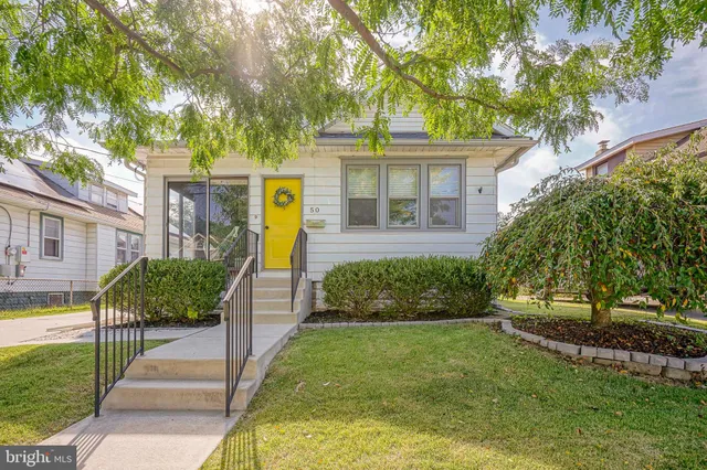 a front view of a house with a yard and potted plants