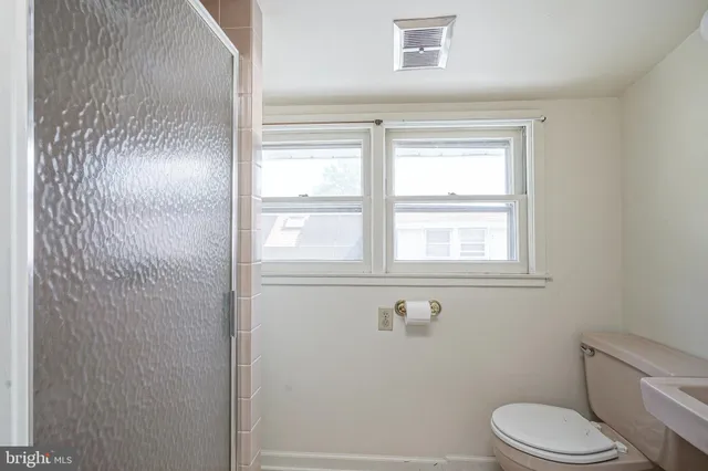 a bathroom with a toilet and a shower