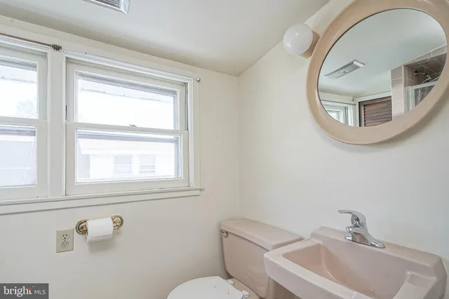 a bathroom with a toilet sink and mirror