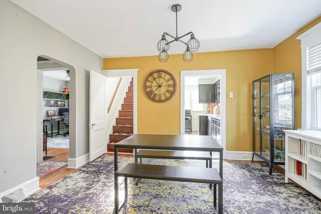 a dining room with furniture a rug and a clock