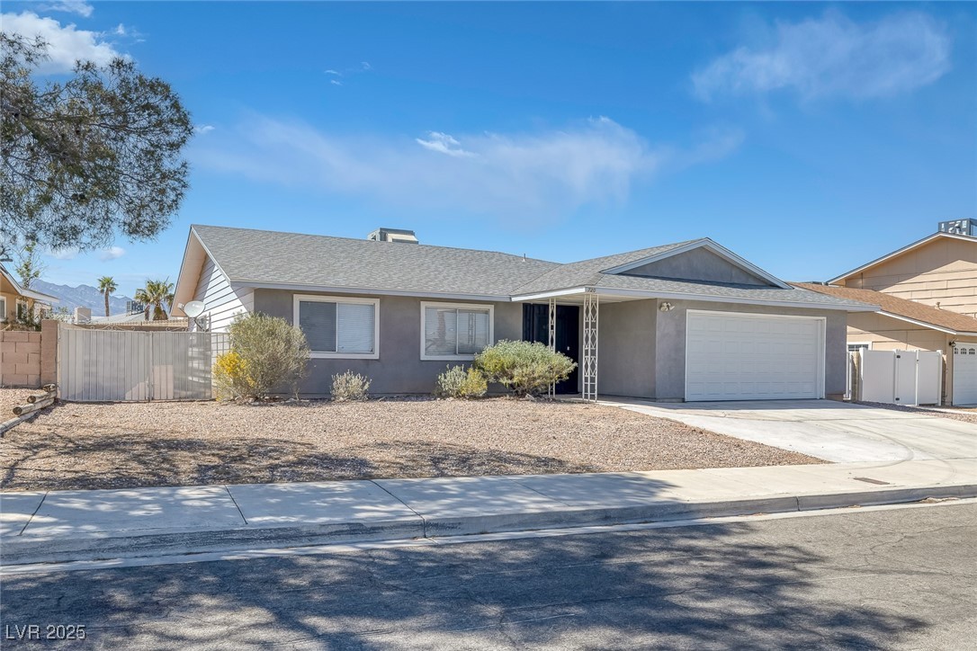 Single story home featuring concrete driveway, a s
